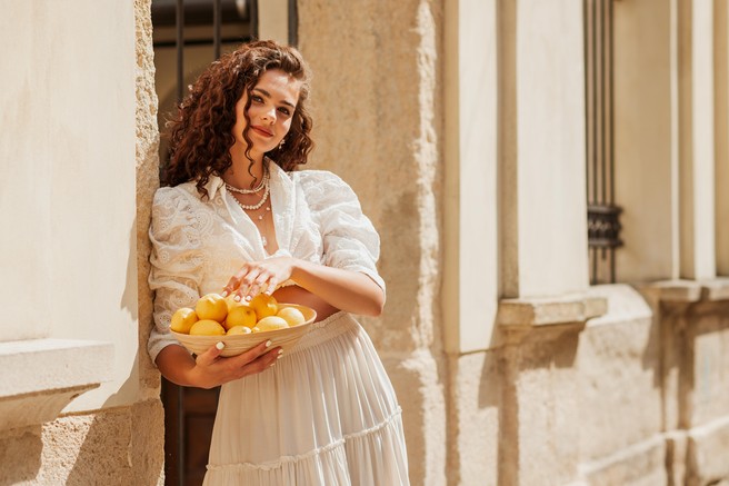 navdih sredozemlja, kamnita ulica in ženska z limonami