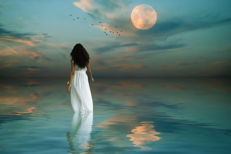 ženska stoji v vodi, luna na nebu, v vodi odsev (foto: shutterstock)