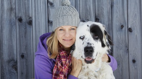 Ženska s kapo objema svojega psa