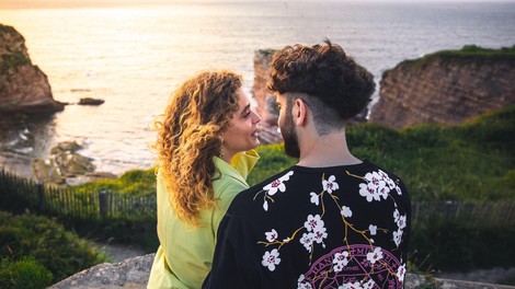 Par na klifu ob sončnem zahodu