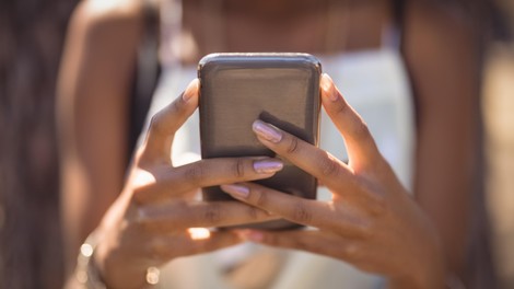 Ženske roke držijo pametni telefon